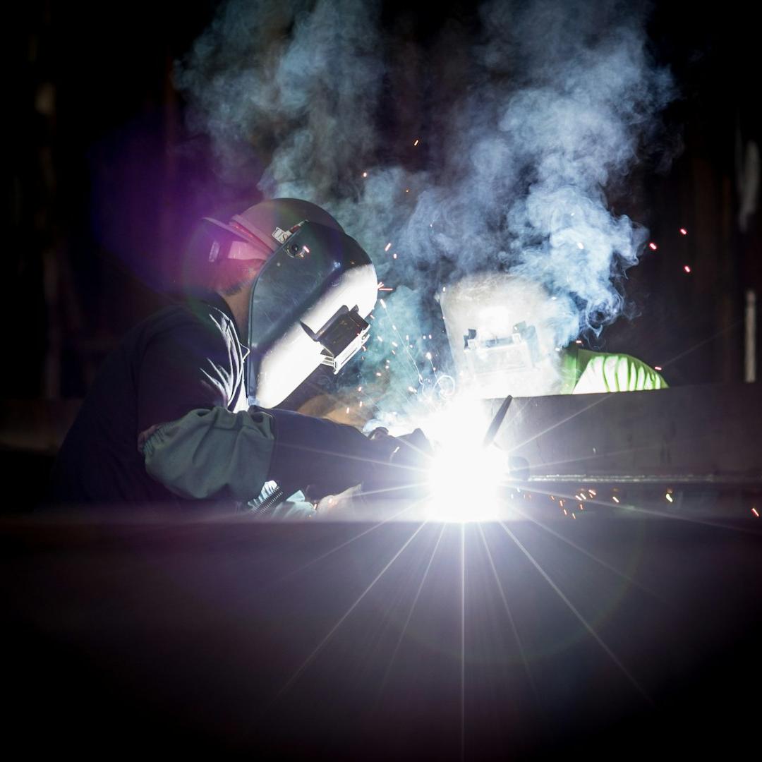 person welding metal using gray helmet